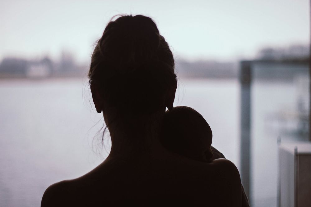 Silhueta de uma mãe abraçando o filho